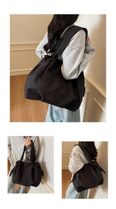 Detailed view of black canvas tote bag showing bow decoration and sturdy shoulder strap