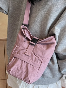 Sac bandoulière en nylon rose avec fermeture à boucle et détails zippés pour mode décontractée
