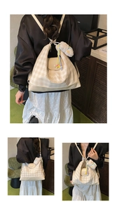 Detail of hobo bag in beige checkered canvas with Luckygirl embroidery and plush pendant