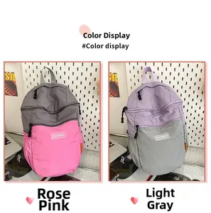 Dettaglio di zaini in nylon bicolore nei colori a contrasto rosa e grigio chiaro