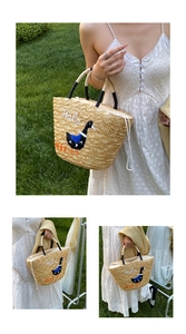 Detail of straw tote bag showing duck embroidery, hola text and white drawstring closure
