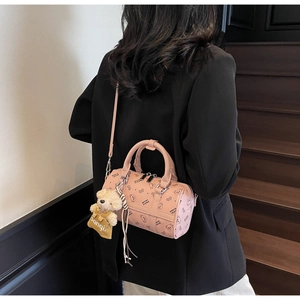 Detailed view of a pink Boston bag featuring bear patterns and a cute plush charm