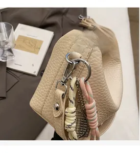 Detail of cream leather tote with silver hardware and decorative tennis racket charm