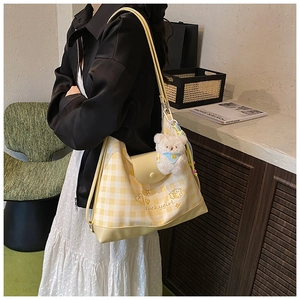 Detail of yellow plaid canvas tote bag with Luckygirl embroidery and plush bear charm