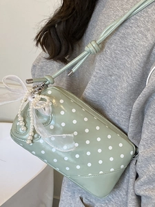 Light green polka dot baguette bag with pearl bow charm and slim shoulder strap