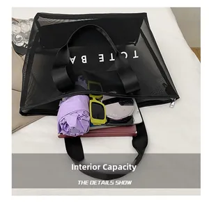 Détail montrant la capacité intérieure du sac cabas en filet noir avec divers objets