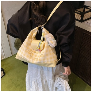 Detail of yellow checkered tote bag with Luckygirl print and cute plush rabbit charm