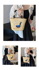 Detail of straw tote bag featuring Hola embroidery and woven rope handle for vacation