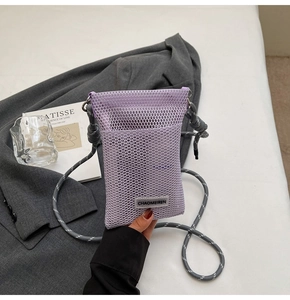 Detail of purple mesh phone bag with woven label on a stylish grey background