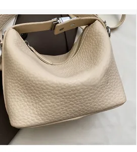 Detail view of the beige lychee-patterned tote bag with silver hardware and zipper