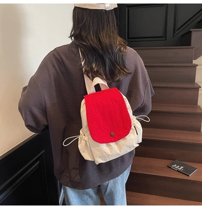 Detail shot of the red and cream contrast canvas backpack featuring drawstring sides