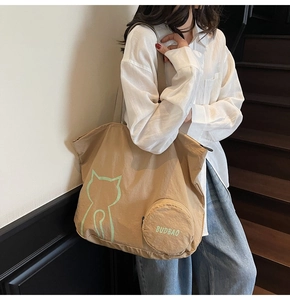 Detail of khaki canvas tote bag with green cat print and round matching coin purse
