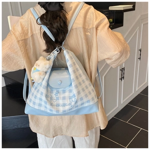 Detail view of light blue checkered backpack with cartoon rabbit and lucky girl graphics