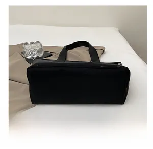 Détail de la base renforcée résistante à l'usure sur un grand sac cabas noir