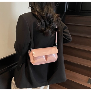 Pink rectangular baguette bag with embossed Paris text worn by a model on stairs