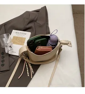 Detail showing high capacity of beige pebble leather bag with phone and wallet inside