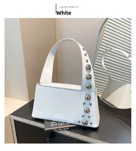 Detail view of white punk style handbag with metallic silver rivets and smooth finish