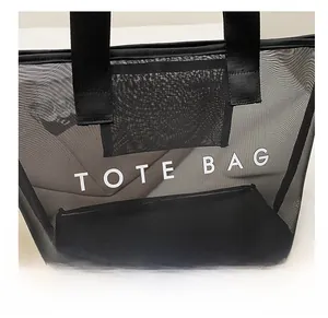 Gros plan du sac cabas en maille noire avec l'inscription blanche TOTE BAG