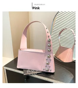 Detail of light pink shoulder bag with stylish silver metal studs and asymmetric design