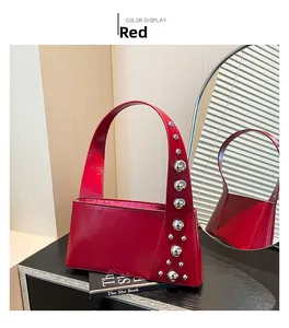 Detailed view of red punk handbag with silver rivets reflected in a round mirror