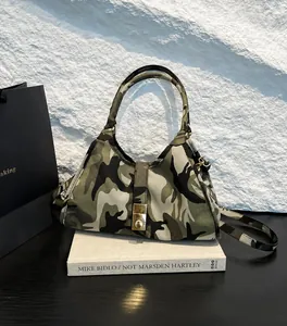 Detail view of camouflage hobo bag with metallic clasp closure and sturdy top handle