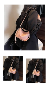 Detailed view of pink lychee leather handbag with fringe tassels and metal buckle