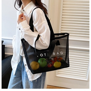 Détail d'un sac cabas en maille noire transparente avec inscription et fruits à l'intérieur