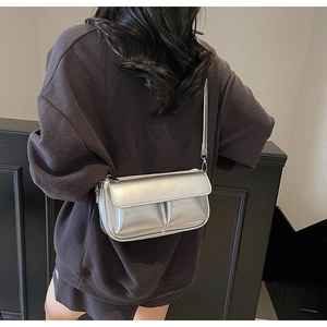 Detailed view of silver metallic crossbody bag with Paris embossing on adjustable strap