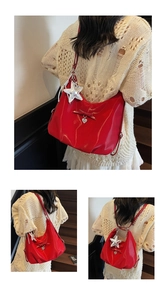 Detail of red patent leather bag with star charm and bow accessory in indoor setting