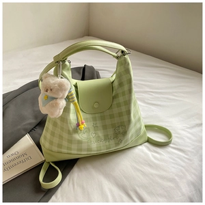 Detail of green plaid shoulder bag with bear pendant and Luckygirl embroidery