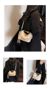 Detail view of cream lychee texture leather handbag with tassel and detachable strap