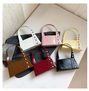Detail showing various colors of shiny leather handbags with metal stud decorations