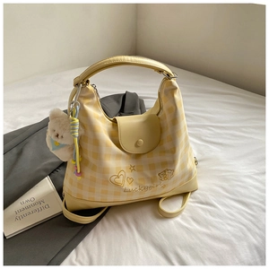 Detail of yellow plaid crossbody bag with Luckygirl embroidery and plush bear charm