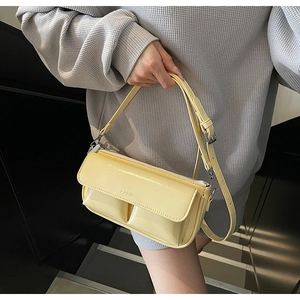 Detail showing two front pockets and PARIS engraving on yellow baguette shoulder bag