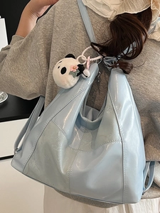 Light blue patent leather hobo bag with cute panda plush charm and geometric stitching