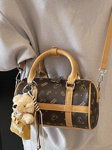 Brown Boston cylinder crossbody bag with bear pattern and plush bear charm