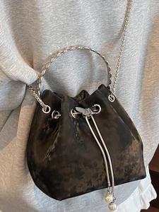Retro black bucket bag with silver metal ring handle, pearl charms, and chain strap
