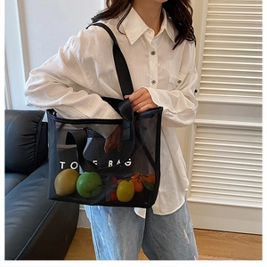 Vue détaillée du grand sac cabas en filet noir avec lettrage TOTE BAG blanc et sangle