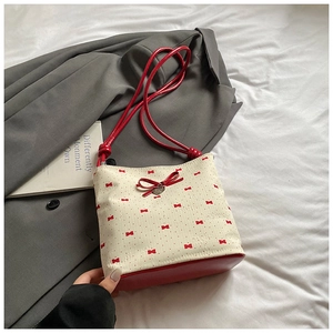 Detail view of canvas bucket bag with red bows, polka dots and heart charm decoration