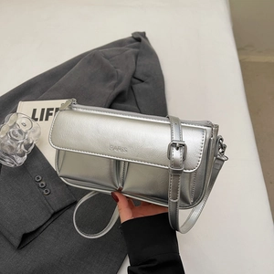 Close-up of metallic silver baguette bag with Paris embossing and adjustable strap