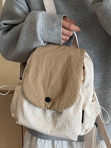 Minimalist cream and khaki canvas backpack with flap cover and drawstring side pockets