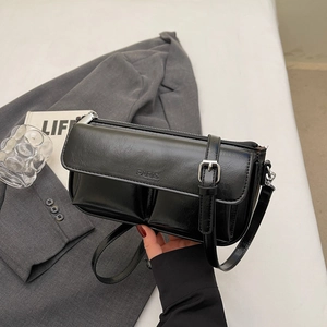 Detail of black faux leather bag with Paris logo and adjustable silver buckle strap