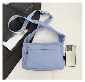 Detailed top view of light blue nylon crossbody bag showing spacious front zipper pocket