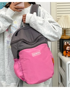 Dettaglio dello zaino in nylon bicolore con tessuto impermeabile e pratiche tasche laterali