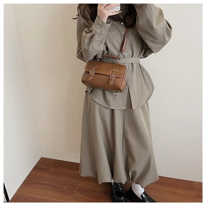 Mirror selfie showing a vintage dark brown leather crossbody bag with embossed logo detail