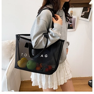 Détail du sac cabas en maille noire montrant sa grande capacité remplie de fruits