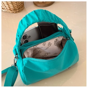 Détail de l'intérieur du sac Boston turquoise avec bandoulière tressée et logo DAIOU