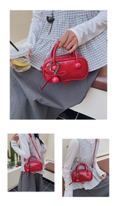 Detailed macro view of a red patent leather pillow bag with festive beaded bow charm decor