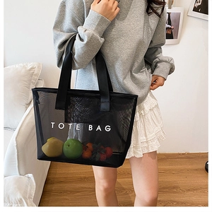 Sac fourre-tout en filet noir avec imprimé TOTE BAG montrant une grande capacité à l'épaule