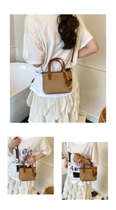 Detail of canvas handbag featuring brown leather trim and a classic horse charm accessory